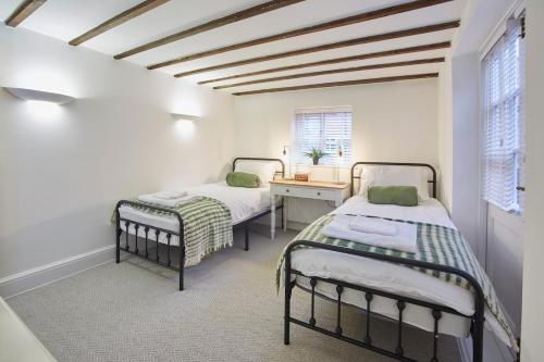 a room with two beds and a desk and a window at Fantastic Grade II listed renovated coach house in Hull