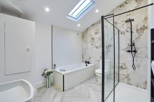 a bathroom with a bath tub and a toilet at Fantastic Grade II listed renovated coach house in Hull