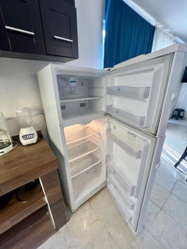 a white refrigerator with its door open in a kitchen at CASA HUELLAS EN LA ARENA in Ixtapa