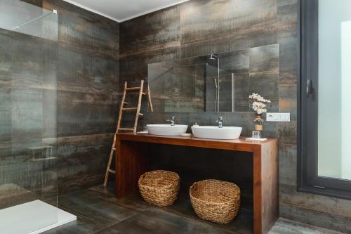a bathroom with two sinks and a mirror at Casas De Bouro 2 Casa Dos Jarros in Terras de Bouro