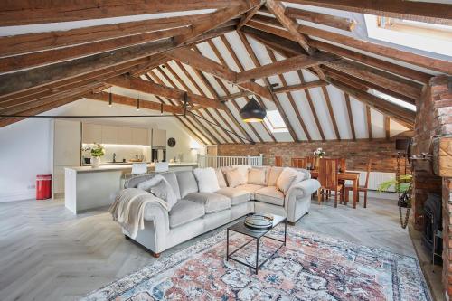 a living room with a couch and a table at Fantastic Grade II listed renovated coach house in Hull