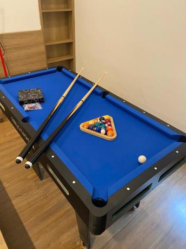 a pool table with cue sticks and balls on it at Nhà Bơ Homestay 2 in Danang