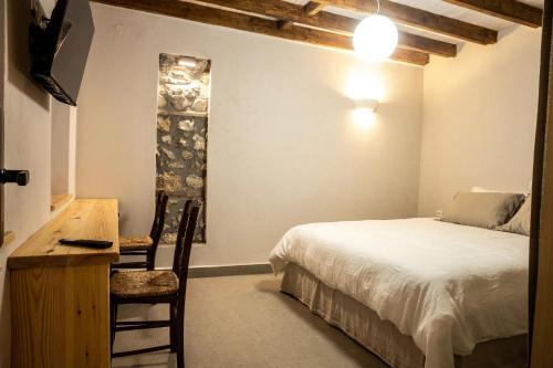 a bedroom with a bed and a table and a desk at Vevi Villas in Vévi