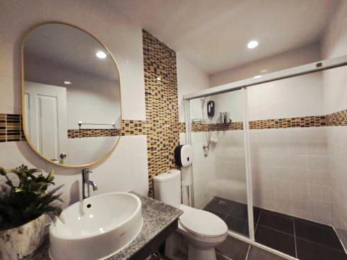 a bathroom with a sink and a toilet and a mirror at The Atlas hostel Muang Thong Thani in Thung Si Kan