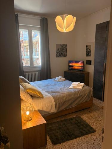 a bedroom with a large bed and a television at GuestHouse Modena Buon Pastore in Modena