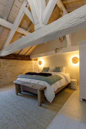 a bedroom with a large bed and a wooden ceiling at Maison Girardine in Rauzan