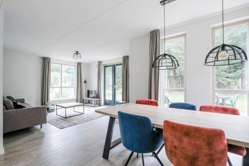 a living room with a dining room table and chairs at Sfeervol wellnesshuis met privé sauna en tuin in Ewijk