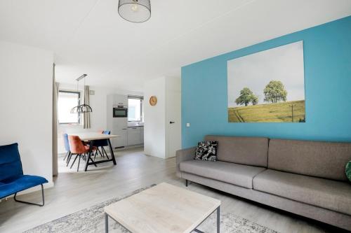a living room with a couch and a blue wall at Sfeervol wellnesshuis met privé sauna en tuin in Ewijk