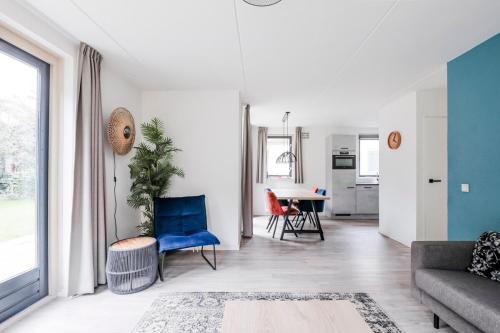 a living room with a couch and a table at Sfeervol wellnesshuis met privé sauna en tuin in Ewijk