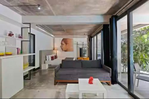 a living room with a couch and a table at Modern Apartment with Shared Pool - By the Beach in Seminyak