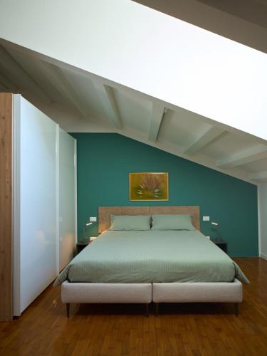 a bedroom with a large bed with a blue wall at Le Mura Minicase int 4 in Castelfranco Veneto