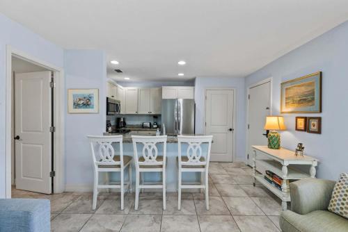 a kitchen with a table and chairs in a room at Le Monaco - 1 BR Romantic Condo! Getaway Steps from 5th Ave S Stylish Coastal Retreat with King Bed Beach Access and Prime Location, Near Dining Shopping and Sunset Views! in Naples