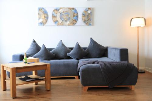 a living room with a blue couch and a table at Brand New, 5min to Ski PARADISE ! in Grindelwald