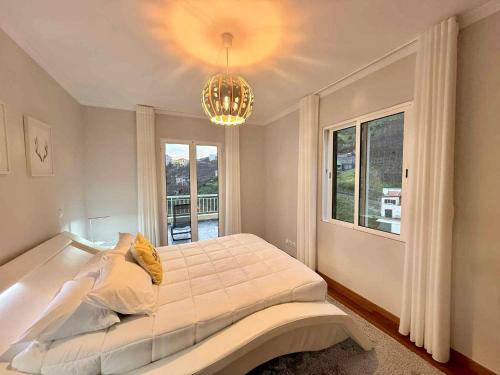 a bedroom with a large bed and a chandelier at Vista Verde in Estreito de Câmara de Lobos