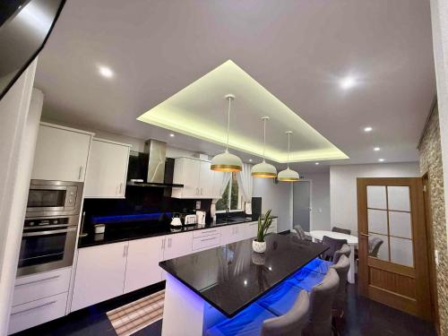 a kitchen with white cabinets and a black counter top at Vista Verde in Estreito de Câmara de Lobos