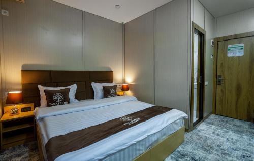 a bedroom with a large bed in a room at Zarafshon Garden Hotel in Bukhara