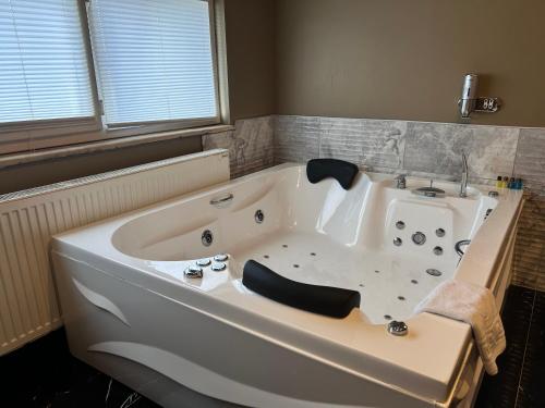 a large white bath tub in a bathroom at Centrum Hotel in Ankara