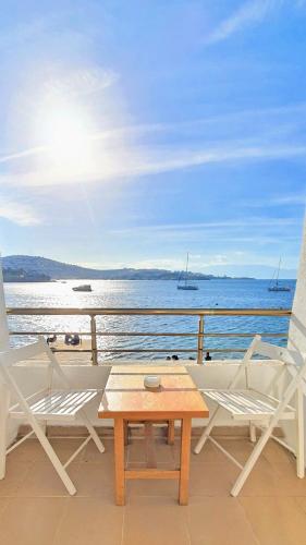 a table and chairs on a balcony with the ocean at Midilli Konak Foca in Foça