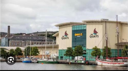 a large building with boats docked in a harbor at Park View Apartment Newry in Newry