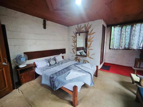 a bedroom with a bed and a mirror in it at Munnar Tree house and Farm in Munnar