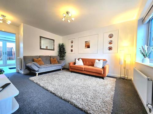 a living room with two couches and a rug at The Charm Luxury House - 8mins to NEC, Birmingham Airport in Marston Green