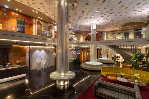 a lobby on a cruise ship with a couch and columns at SH Valencia Palace in Valencia