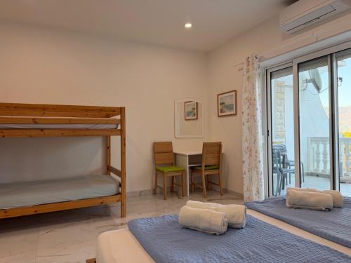 a bedroom with two bunk beds and a desk at Apartements Magdalena in Lopar