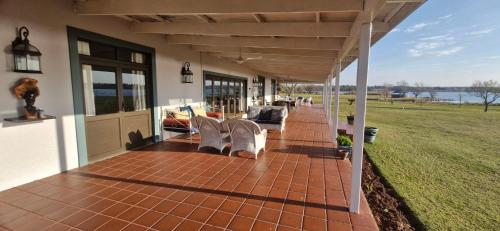 a porch of a house with chairs on it at Riverside Farm in eMalahleni