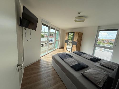 a bedroom with a large bed and a flat screen tv at Apartmenthaus MK Immobilien in Stuttgart