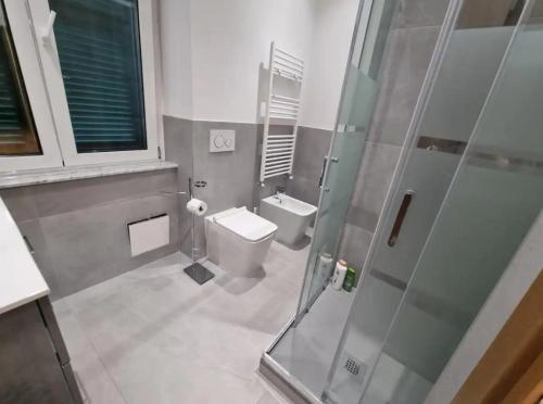 a bathroom with a toilet and a glass shower at Queen Barbara in Genoa