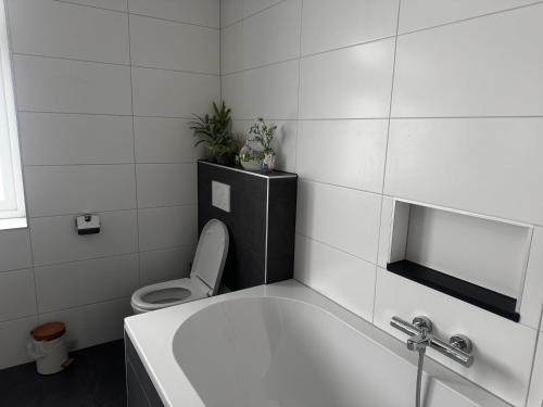 a bathroom with a toilet and a bath tub at Bed en Bike Oudeschild in Oudeschild