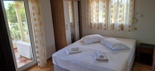 a bedroom with a white bed with towels on it at Makis Nest Apart-Hotel in Vourvourou