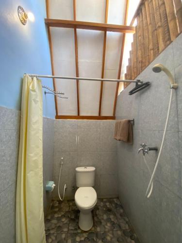 a small bathroom with a toilet and a shower at Bale Baleku Homestay in Praya