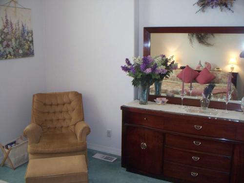 a room with a dresser and a chair and a mirror at River Cove Elegant Waterfront Bed & Breakfast in Post Falls