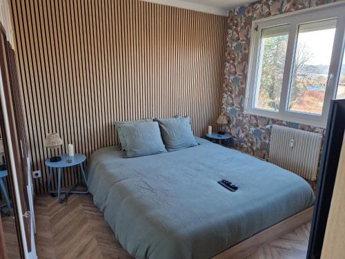 una camera da letto con un letto grande con due tavoli di La détente a Lons-le-Saunier