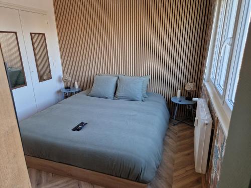 una camera da letto con un letto con un telecomando di La détente a Lons-le-Saunier