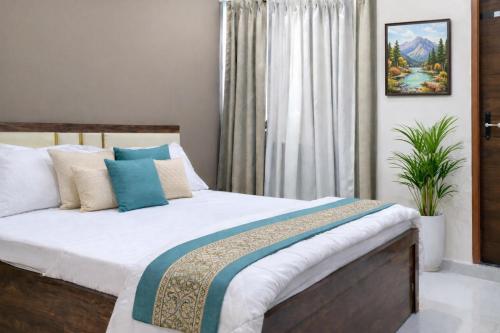 a bedroom with a bed with white and blue pillows at Ekaay The Boutique Hotel in Kumārkara