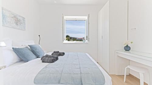 a white bedroom with a teddy bear on a bed at Luxury Apartment Nala with shared pool in Sevid