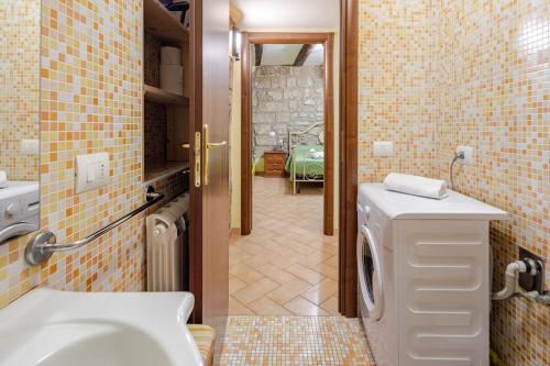 a bathroom with a sink and a washing machine at The Stone House Historic Center in Grotte di Castro
