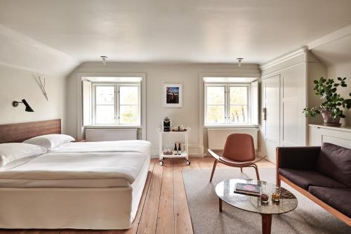 a bedroom with a large bed and a couch at Hotel Skeppsholmen, Stockholm, a Member of Design Hotels in Stockholm
