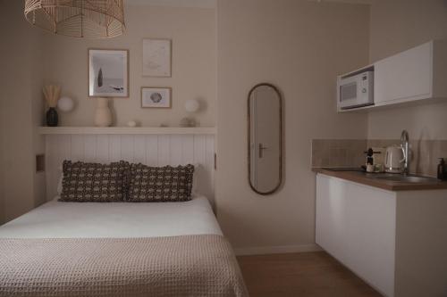 a small bedroom with a bed and a sink at Sézam Appart’Hôtel Saint-Malo in Saint Malo