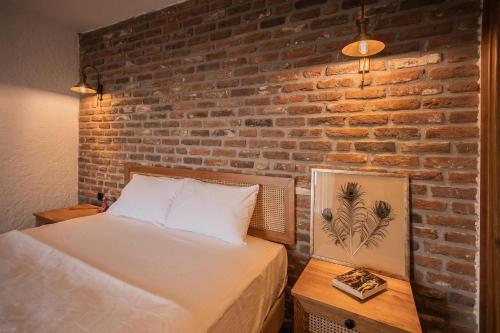 a bedroom with a bed and a brick wall at Kaira Kazdaglari in Edremit