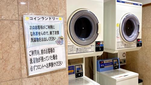 a washing machine and a washer and dryer in a bathroom at Toyoko Inn Niigata Furumachi in Niigata