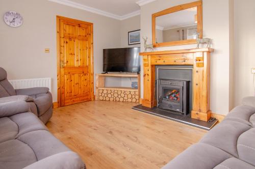 a living room with a fireplace and a tv at Sea View Heights in Rathmullan