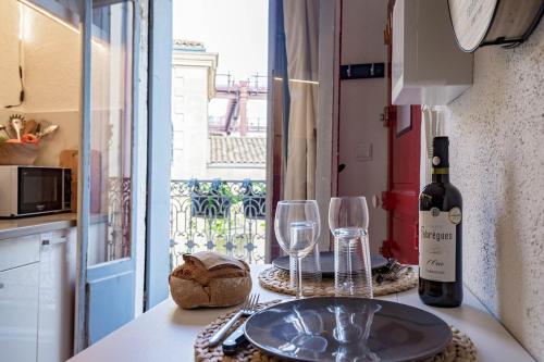 a table with a bottle of wine and two glasses at Vidéoprojecteur - Tout à pied - Centre - Balcon in Montpellier