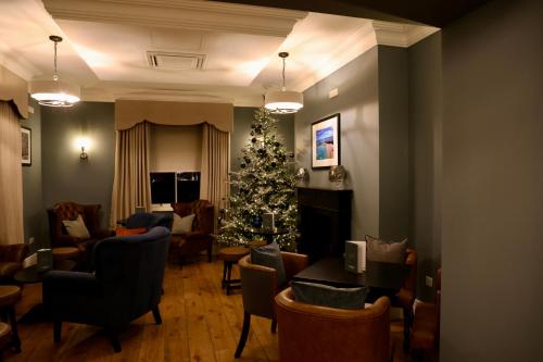 a living room with a christmas tree and chairs at Y Seren Hotel & Restaurant in Carmarthen