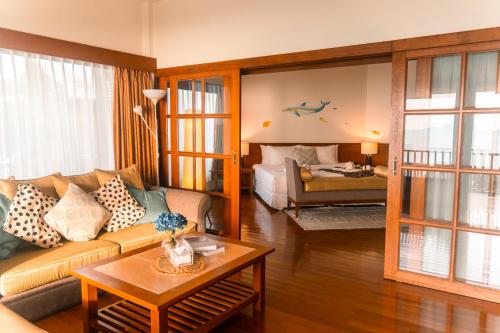 a living room with a couch and a bed at Birds and Bees Resort in Pattaya South