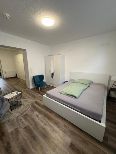 a bedroom with a bed and a blue chair at Gemütliche Suite im Erdgeschoss - WLAN in Hinsel
