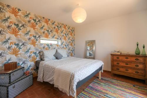 a bedroom with a bed and a floral wall at Mas des Côtes in Saint-Hippolyte-le-Graveyron