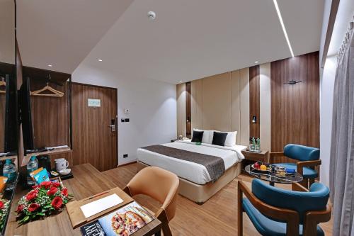 a hotel room with a bed and a table and chairs at Hotel Suba Star Ahmedabad in Ahmedabad